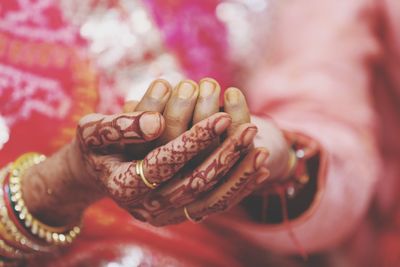 Midsection of bride and groom touching hands