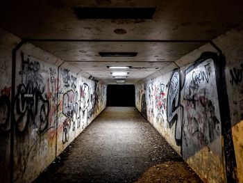 Graffiti on wall in illuminated tunnel