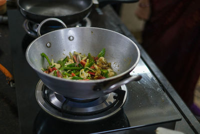 Close up of fresh vegetables prepared in wok on gas stove