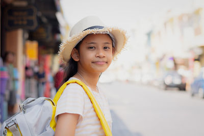 View from behind a little girl with backpack staring to yacht marina under sunlight, travel concept.