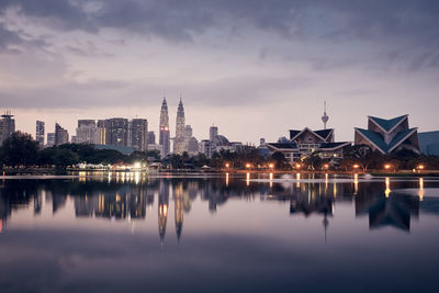 Urban skyline of kuala lumpur at dawn. reflection of skyscrapers in the water surface.