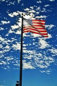Low angle view of american flag against blue sky