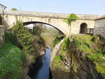 Arch bridge over river against sky