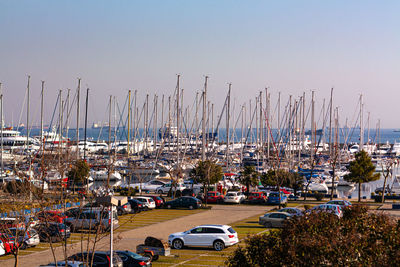 Sailboats moored at harbor against clear sky