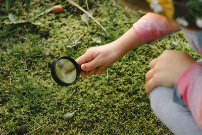 Cropped hand of woman holding magnifying glass