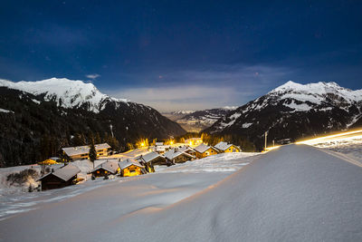 Snow covered landscape against sky at night