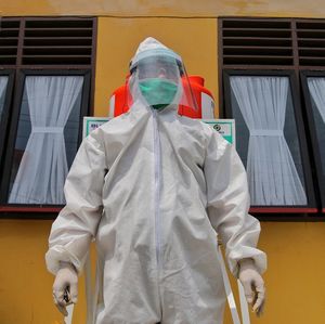 Midsection of person with umbrella standing in front of building