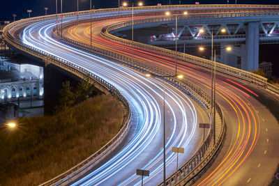 Highway at night lights. fast car light path, trails and streaks on interchange bridge road