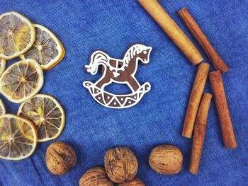 High angle view of gingerbread cookies with lemon and walnuts by cinnamon on table