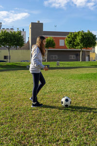 Full length of girl playing soccer on field