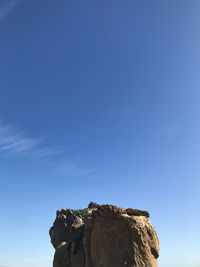 Low angle view of rock formation against clear blue sky