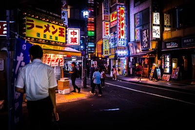 People at illuminated city street at night