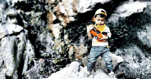 Full length of boy standing on rock