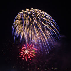 Low angle view of fireworks against sky at night