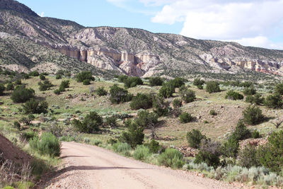 View of dirt road along rocky mountains