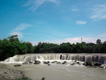 Scenic view of waterfall against sky