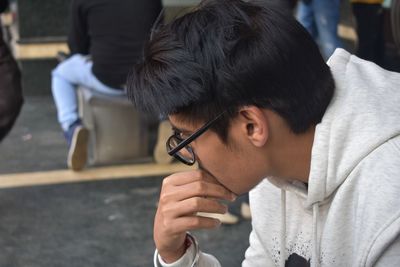 Portrait of man holding cigarette on street