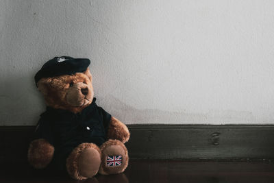 Boy sitting on toy against wall at home