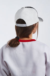 Rear view of woman wearing hat against white background