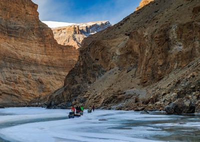 People walking on snow covered mountain against sky