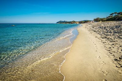 Scenic view of beach against blue sky