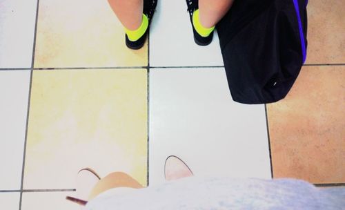 Low section of woman standing on tiled floor