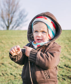 Portrait of mature man holding hat on field