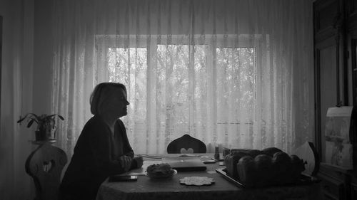 Senior woman sitting at dinning table at home