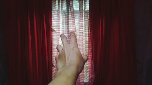 Man's hand touching curtain 