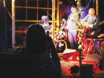 Rear view of people playing at music concert