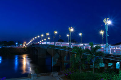 Illuminated bridge over canal in city at night