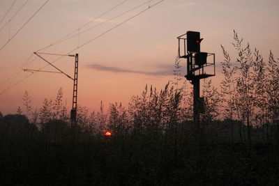 Silhouette train light against sky during sunset