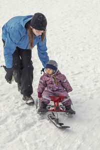 Father pushing toddler on snowbike