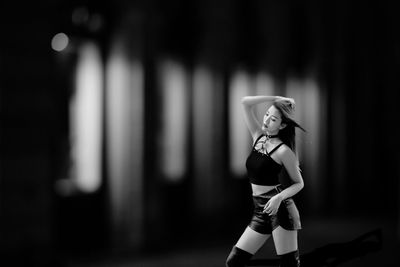 Young woman standing against wall