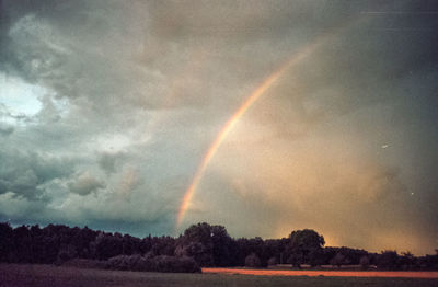 Scenic view of rainbow over field against sky