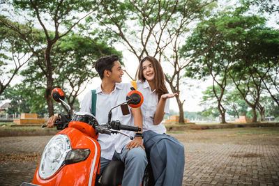 Side view of man riding motor scooter on field