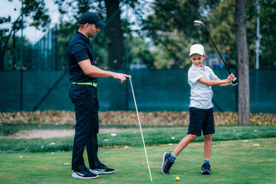 Full length of a man playing soccer on golf course