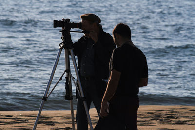 Cinematographic set, backlit cameramen with sunset sea background