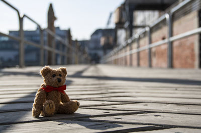 Teddy bear on footpath against sky