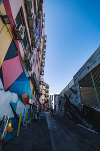 Street amidst buildings against blue sky