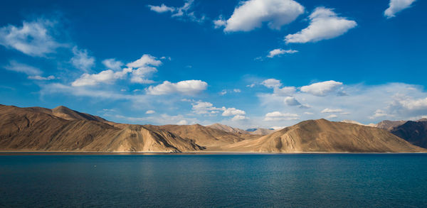 Panoramic view of lake and mountains against blue sky