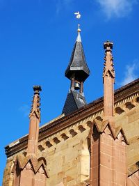 Low angle view of bell tower against blue sky