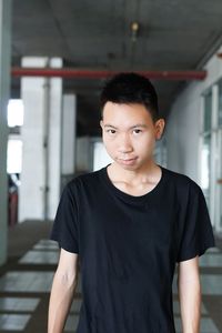 Portrait of young man standing in sidewalk of parking lot