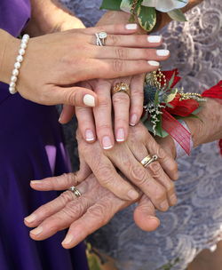 Four generations of women's hands placed on top of each other showing wedding bands at a wedding