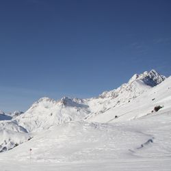 Scenic view of snowcapped mountain against blue sky