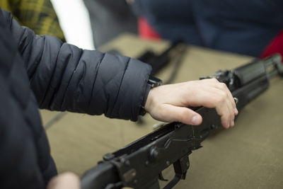 Midsection of man holding gun