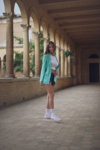 Full length of young woman standing in tunnel