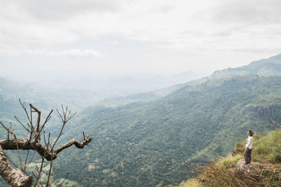 Woman standing on mountain against sky