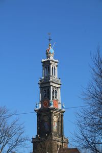 Low angle view of bell tower against blue sky