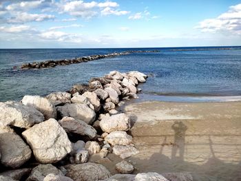 Rocks by sea against sky